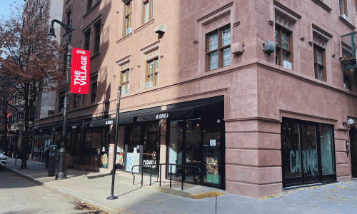 Carmela Coffee Greenwich Village corner view showing the black awnings, large windows, brownstone-style building, and a quiet tree-lined street.