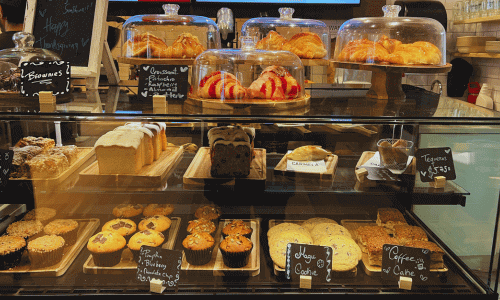 Carmela Coffee Greenwich Village pastry display featuring assorted baked goods arranged behind the counter in a warm, inviting café setting.