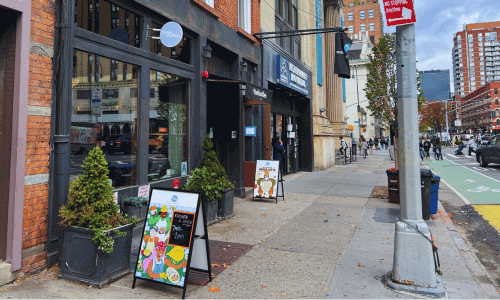 Think Coffee West Village – Fair-Trade Coffee Shop NYC 1 Think Coffee West Village, showing the brick storefront, sidewalk signs, and people walking along a busy NYC block.