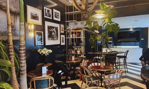 Café Flor Chelsea interior with bistro-style seating, framed wall art, indoor plants, and a cozy café atmosphere in Chelsea, Manhattan.