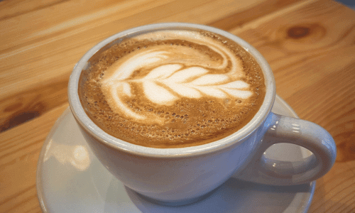 Close-up of a latte with detailed leaf-shaped latte art served at Coffee Project New York in Chelsea, Manhattan.