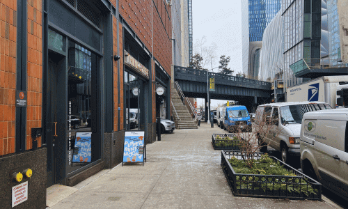 Exterior view of Think Coffee near Hudson Yards in Chelsea, showing the sidewalk entrance, nearby buildings, and the High Line walkway in the background.