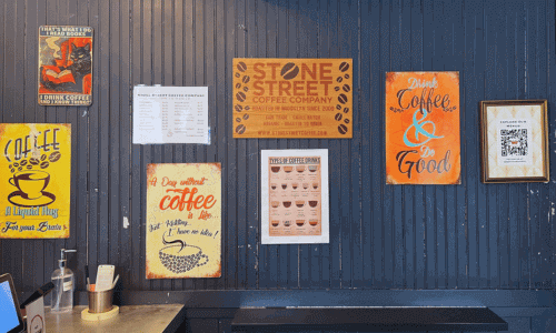 Coffee-themed wall decor inside Stone Street Coffee Chelsea in Manhattan NYC grab and go espresso bar