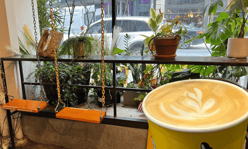 787 Coffee Chelsea – Best Puerto Rican Coffee NYC 3 cafe latte with street view from inside 787 Coffee Chelsea near Madison Square Garden and Hudson Yards NYC