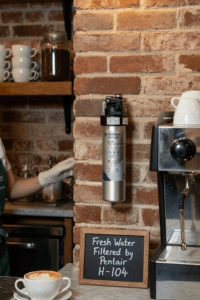 Pentair Everpure H-104 water filter system installed next to espresso machine in coffee shop
